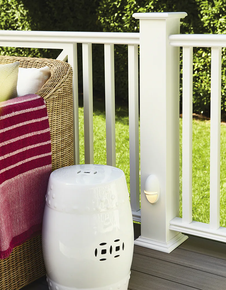 An accent light glows on the bottom portion of the deck railing post