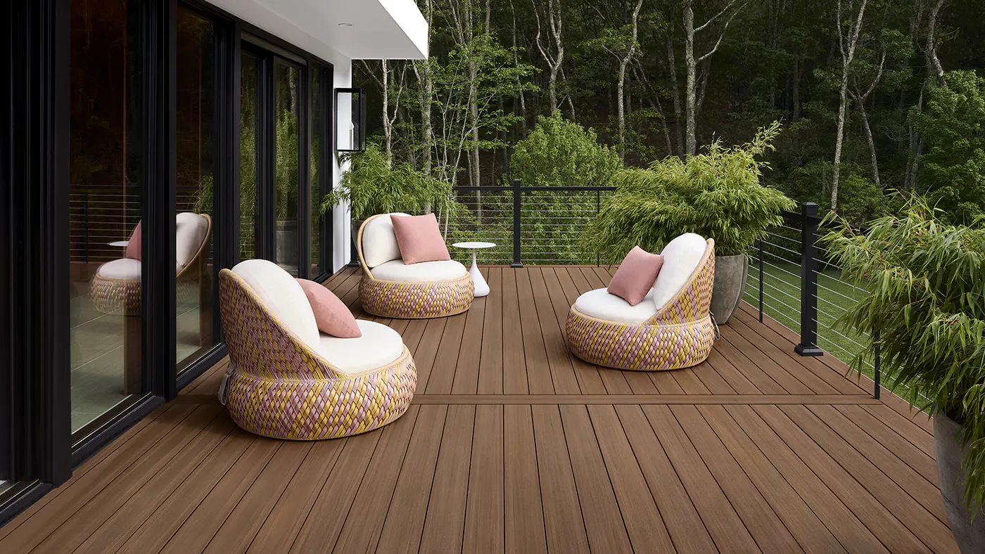 The deck in the shade, the deck boards appear slightly more dark brown out of the direct sunlight. Three chairs face one another.