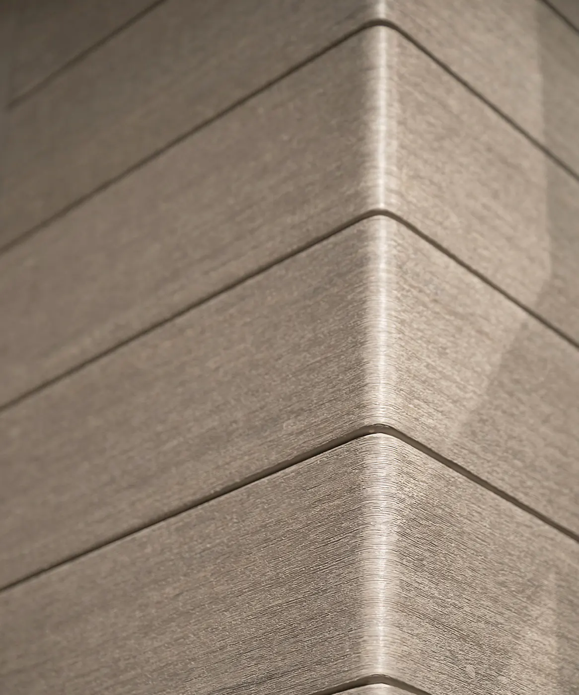 Close up photo of where the cladding is uniformly bent to create a right angle on the house. The light reveals a delicate wood grain on each cladding board.