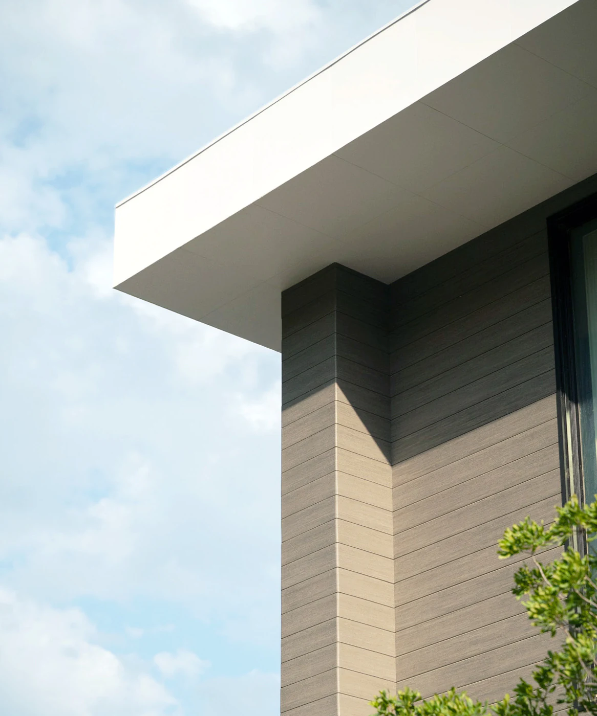 Edge of home with shot of where the gray cladding meets the roof.