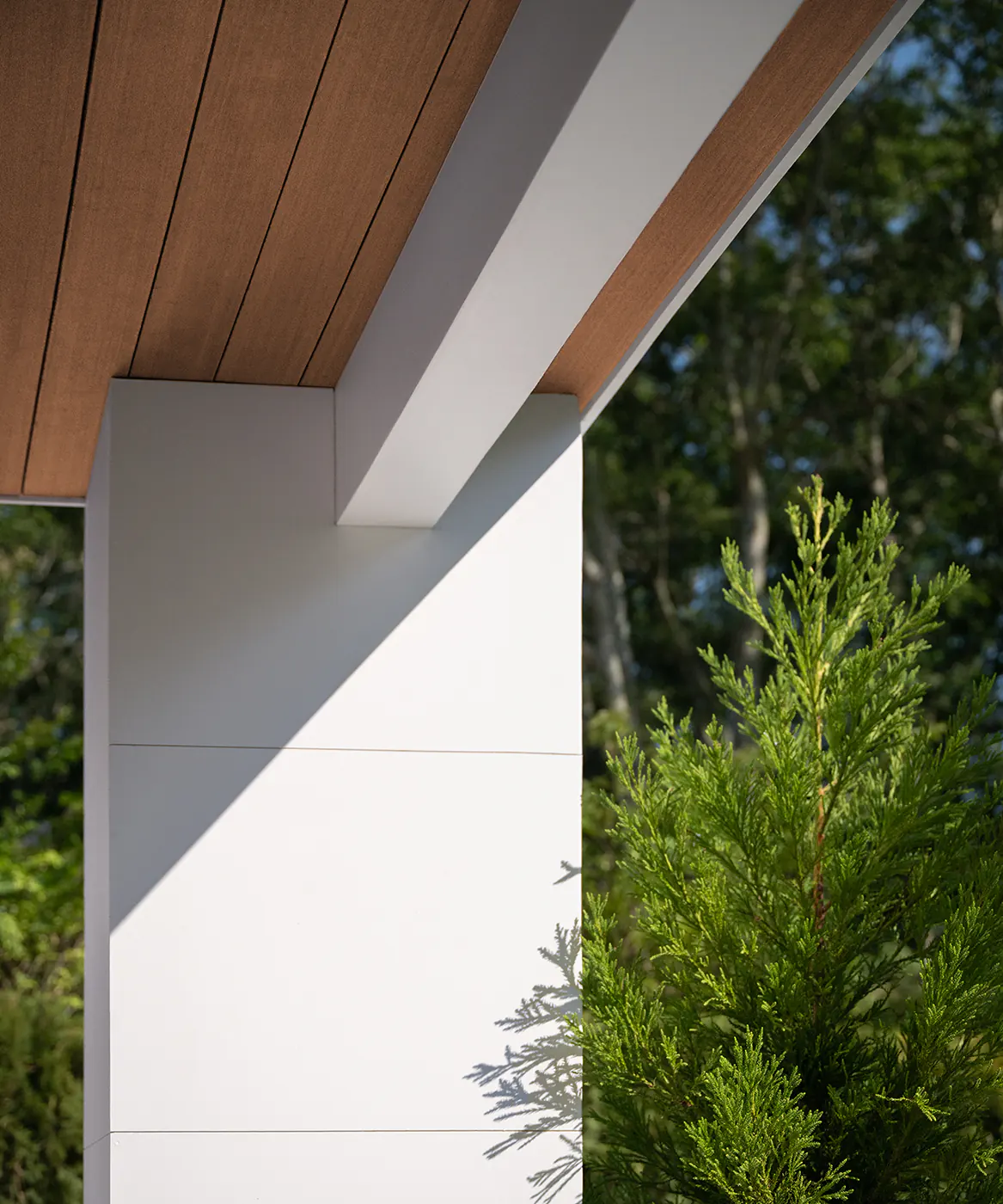 Detail shot of where the pillar meets the second story deck, the same deck boards used on the ceiling create a comfortable, finished feeling to the space.