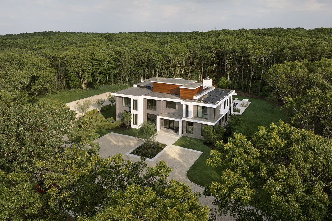 Aerial drone shot of the home on a large property surrounded by trees.