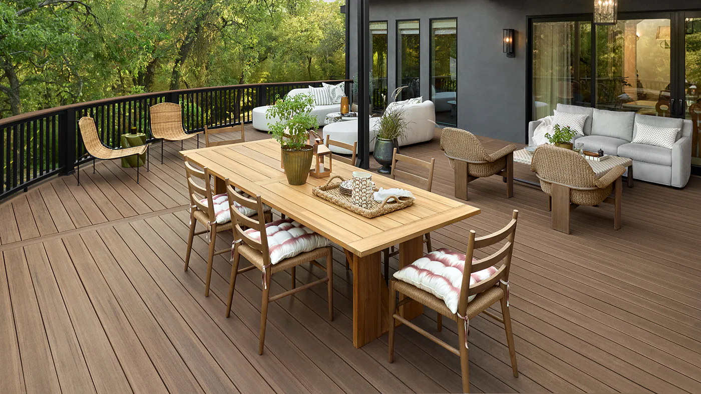 An outdoor dining room table and chairs introduce warm wooden tones complementing the rich brown hues of the deck boards below