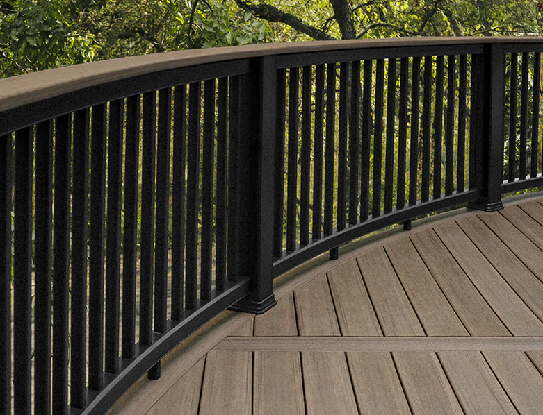 Curved composite black railing with vertical baluster infill. A deck board is used as the top rail.
